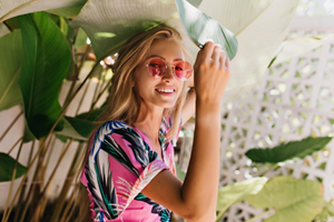 Blonde woman with fine hair wearing pink sunglasses